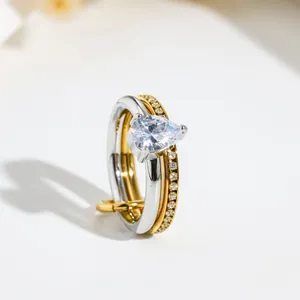Detailed view of dual-band stainless steel ring featuring a pear-cut clear gemstone