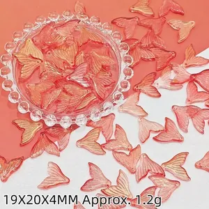 Gros plan de breloques en verre en forme de queue de poisson orange-rose pour DIY