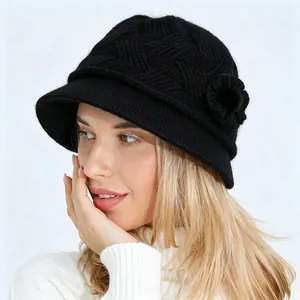 Detalle de gorro cloché de punto negro para mujer con flor y textura de lana cálida