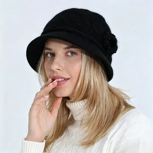 Vista detallada de un elegante sombrero de punto negro con detalle de flor para el invierno