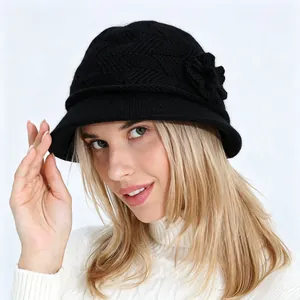 Primer plano de un sombrero cloche de punto negro para mujer con detalle de flor