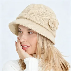 Primer plano de un sombrero cloche de punto beige para mujer con flor decorativa