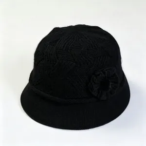 Detalle de un sombrero de pescador de punto negro para mujer con un elegante adorno