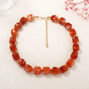 Detailed macro view of a resin square beaded choker necklace in orange-red