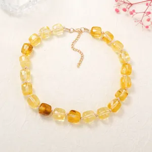 Close-up view of a minimalist amber translucent resin square bead necklace on white