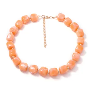Detailed close-up showing the orange resin cube beads with realistic marble texture on a necklace