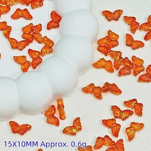 Close-up of translucent orange butterfly glass beads with gold foil effect for DIY
