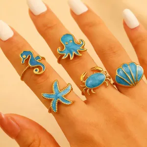 Set di 5 anelli regolabili dorati a tema oceano con creature marine in smalto blu
