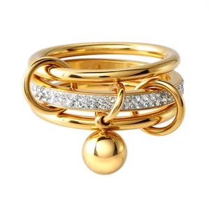Detailansicht eines mehrlagigen goldenen Edelstahlrings mit Kugelanhänger und Zirkonia-Band.