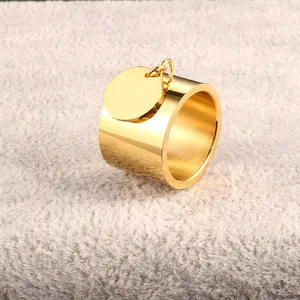 Nahaufnahme eines minimalistischen goldenen Edelstahlrings mit kreisförmigem Anhänger.