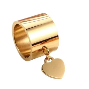 Minimalistischer goldener Edelstahlring mit breitem Band und Herzanhänger für Damen.