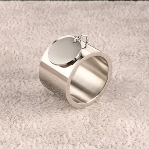 Minimalist stainless steel wide band ring featuring a polished round hanging charm tag