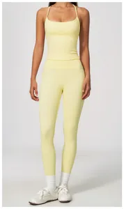 Full body view of women's pale yellow high-waisted yoga leggings and matching tank top