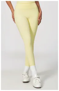 Detail view of pale yellow high-waisted yoga leggings on a fitness model in studio