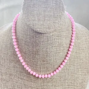 Nahaufnahme einer rosa facettierten Steinperlenkette auf Leinen-Schmuckständer