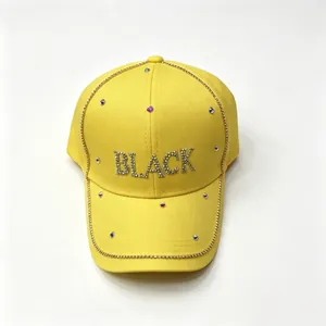 Primo piano di un vivace cappellino da baseball giallo con scritte 'BLACK' in strass luccicanti
