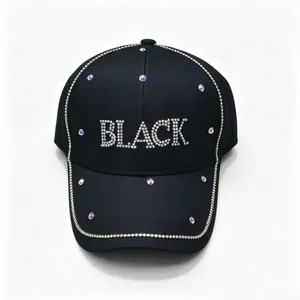 Dettaglio ravvicinato di un cappellino nero con scritta 'BLACK' e accenti in strass.