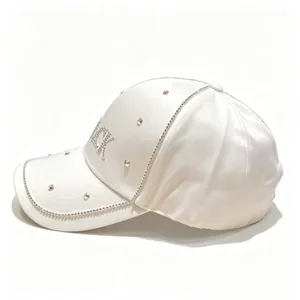 Dettaglio del cappellino da baseball in raso bianco con scritte BLACK in strass.