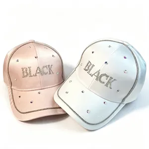 Détail des casquettes de baseball en satin rose et blanc avec lettres BLACK en strass