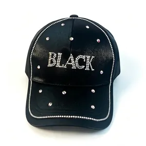 Gros plan du lettrage 'BLACK' en strass étincelants sur une casquette en satin