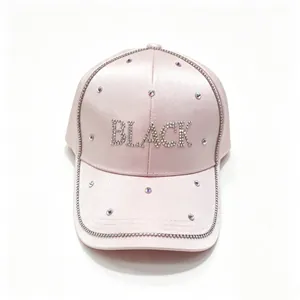 Vista dettagliata del cappello da baseball in raso rosa con scritta 'BLACK' in strass.