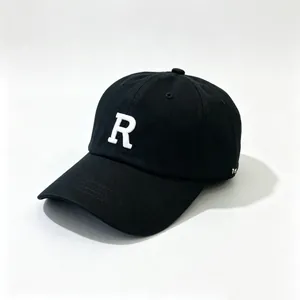 Detalle de cerca de una gorra de béisbol negra con la letra R bordada en blanco