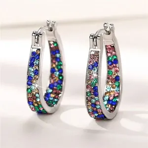 Close-up of colorful rhinestone studded silver hoop earrings in elegant U-shape