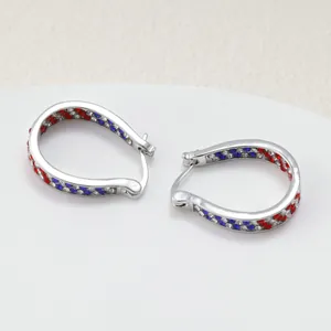 Detail view of silver U-shaped hoop earrings featuring red, blue, and clear rhinestones