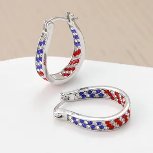 Macro view of silver hoop earrings featuring sparkling red, blue and white rhinestones.