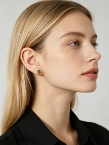 Detailed view of a dainty green flower stud earring in S925 sterling silver on ear.