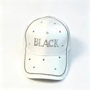 Gros plan d'une casquette de baseball en satin blanc avec lettrage "BLACK" en strass