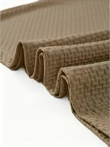 Close-up of brown waffle knit fabric showing detailed texture and mesh pattern