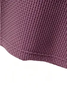 Close-up of the hem on a purple waffle knit mesh t-shirt showing stitching details