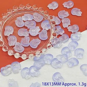 Nahaufnahme von violetten Glasanhängern in Fuchsform für DIY-Schmuck auf einem Glasteller