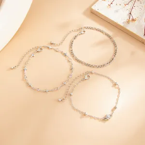 Set of 3 minimalist silver chain anklets featuring delicate charms and Figaro links.