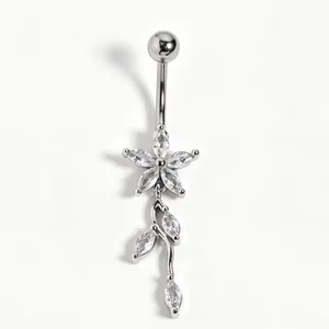 Detailed macro view of silver navel piercing with clear zircon flower and leaf dangle