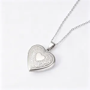 Close-up of silver heart locket necklace with floral engraving and polished center