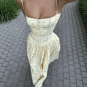 Vue détaillée d'une robe corset fleurie jaune sur une allée de pierre pittoresque