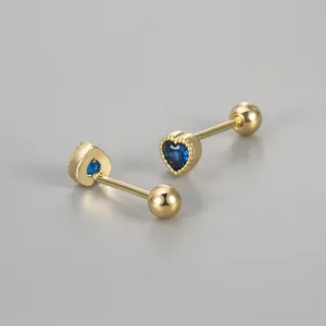 Macro view of gold heart stud earrings featuring blue zirconia stones and secure screw backs
