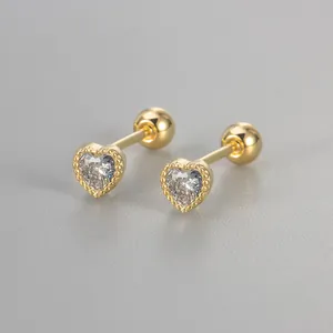 Close-up detail of gold heart stud earrings with cubic zirconia and screw ball back
