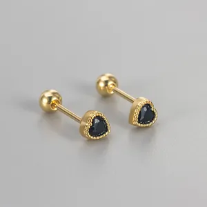 Close-up of heart-shaped gold stud earrings with black zirconia and screw back closures