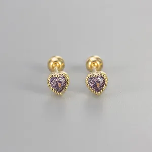 Macro detail of gold heart stud earrings with purple zircon and secure screw backs