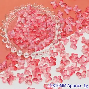 Close-up detail of small pink gradient butterfly glass beads for DIY jewelry making