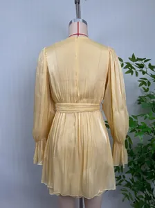 Vue arrière détaillée d'une mini-robe jaune chatoyante avec ceinture à nouer et manches.
