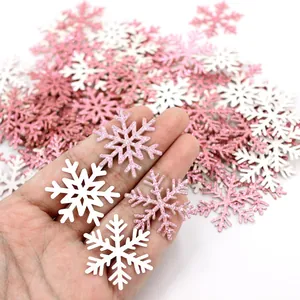 Detailopname van roze glitter en witte sneeuwvlok confetti decoraties in hand