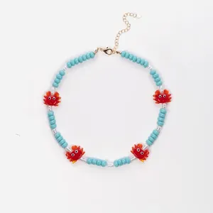 Collier de perles bleu clair avec pendentifs homard rouge et chaîne dorée ajustable