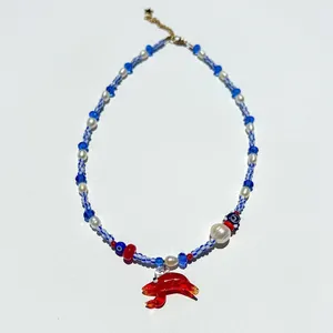 Collier de perles coloré avec un pendentif homard en verre rouge et œil porte-bonheur