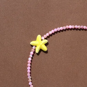 Gros plan d'un collier de perles d'été avec un pendentif étoile de mer jaune vif