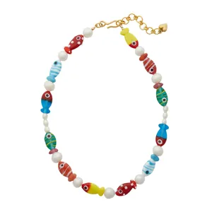 Vue détaillée d'un collier artisanal de poissons en verre coloré et perles avec cœur doré