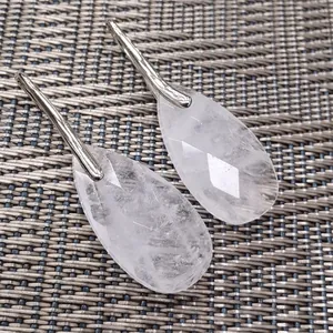 Detailed macro view of faceted clear crystal teardrop earrings with elegant silver hooks.